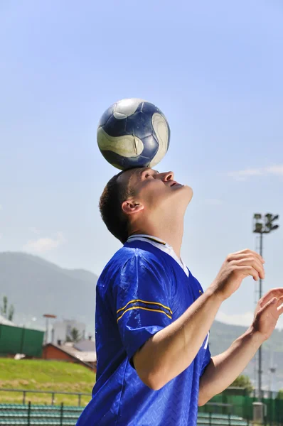 Jugador de fútbol haciendo malabarismos pelota —  Fotos de Stock