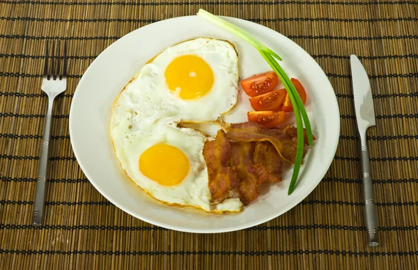 stock image Egg meal yolk fork food onion bacon plate lunch fried green knife fresh tomato hearty cloves dinner scrambled breakfast nutritious