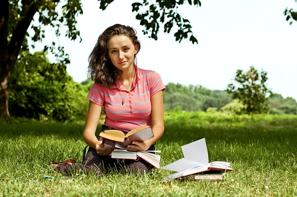 草の上に座って本を読んでいる少女 — ストック写真