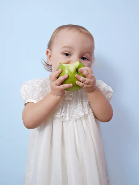 Little girl is eating an apple — Stock Photo, Image