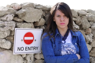 Cute upset girl standing by NO ENTRY sign, expandable white top for text clipart