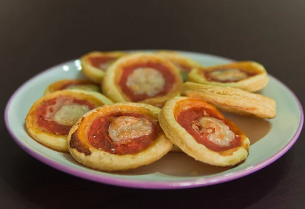 ミニピザいくつか準備ができている白いプレート上のオリーブ、チーズ、トマトのソース — ストック写真