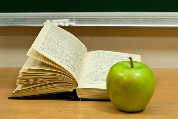 Buch und grüner Apfel — Stockfoto