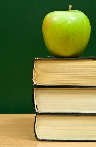 Books and green apple — Stock Photo, Image