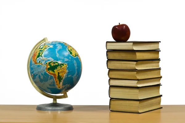 Глобус, яблоко и книги — стоковое фото