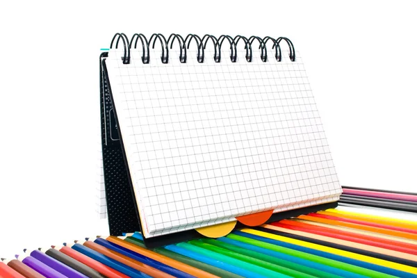 Cuaderno en una celda con lápices —  Fotos de Stock