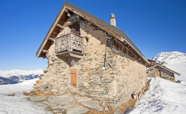 雪に覆われた山腹の伝統的なれんが造りの高山小屋 — ストック写真