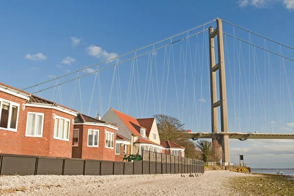 Housing next to a large suspension bridge — Stock Photo, Image
