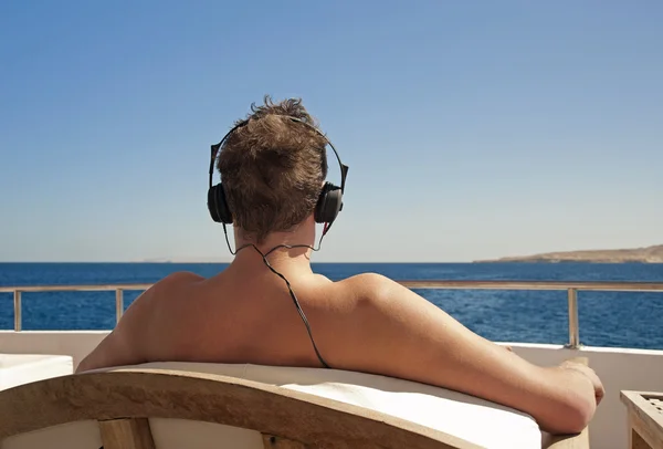 stock image Person relaxing on a boat with headphones