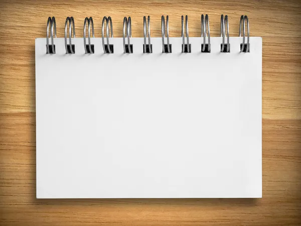 Caderno branco sobre madeira de borracha — Fotografia de Stock