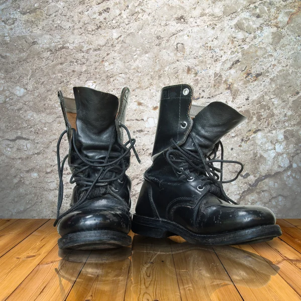 Bota preta velha no chão de madeira — Fotografia de Stock
