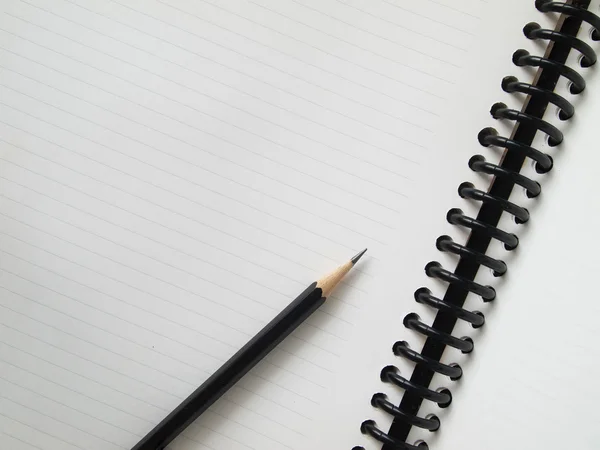 Black pencil on open white paper — Stock Photo, Image