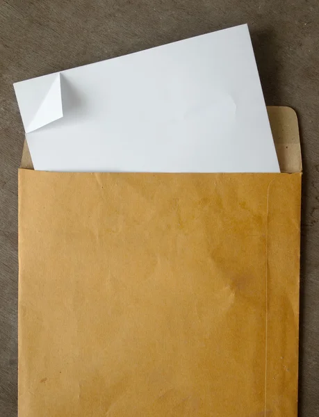 Weißes Papier aus einem braunen offenen Umschlag — Stockfoto