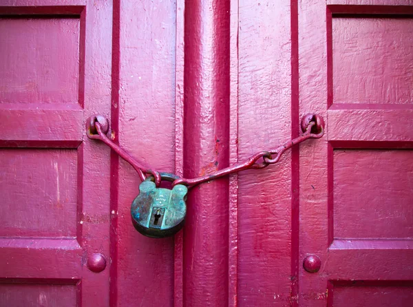 Chave verde na porta de madeira vermelha — Fotografia de Stock