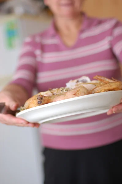 Woman holds dish with fried chicken — Stock Photo, Image
