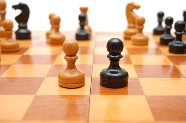 Vintage Chessmenna på schackbräde. vit bricka mot svart. — Stockfoto