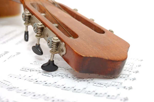 Fingerboard de guitarra antiga sob folha com notas — Fotografia de Stock