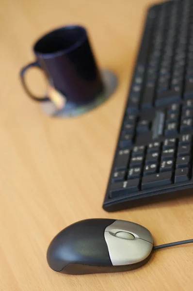 Computador mouse, teclado e xícara na mesa de madeira — Fotografia de Stock