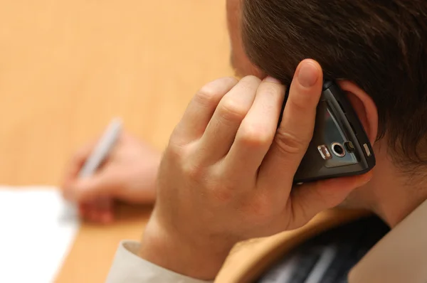 stock image Business man speaks by mobile phone and notices information