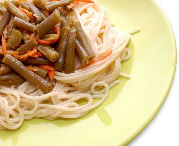 Спагетти с овощами на зеленой тарелке — стоковое фото
