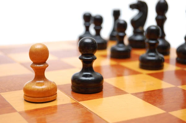 Un peón blanco lucha contra el ejército negro en el tablero de ajedrez . — Foto de Stock