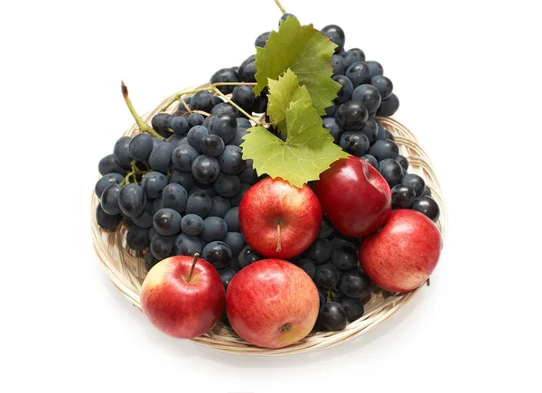 Fresh fruits: grapes and apples in wicker plate — Stock Photo, Image