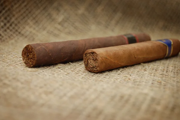 粗麻布画布上的两个古巴雪茄 — 图库照片