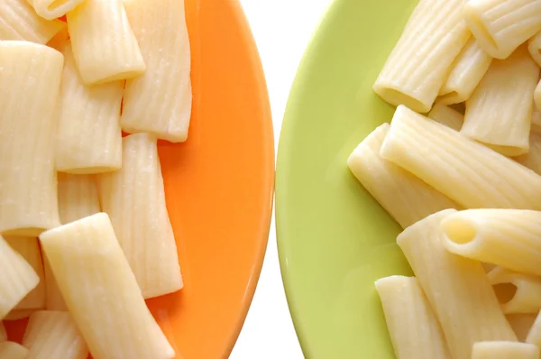 Macarrão alimentos em placas laranja e verde — Fotografia de Stock