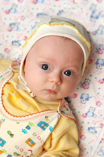 Pequeño niño con grandes ojos azules se encuentra en pañales — Foto de Stock