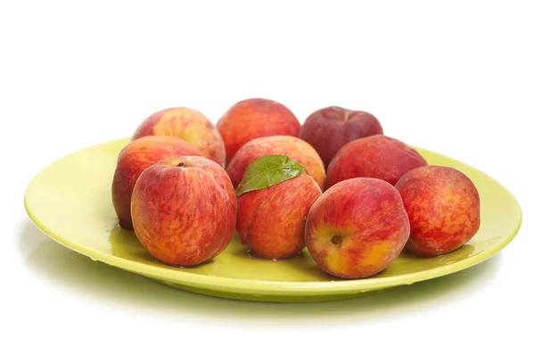 Riped peachs on green plate — Stock Photo, Image
