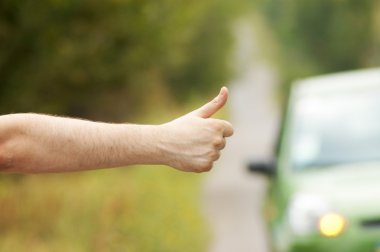 Man hand hitching car on road clipart
