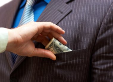 Man putting money into businessman side pocket clipart