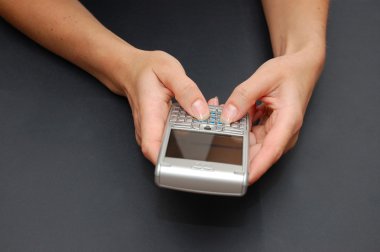 Communicator in woman hands on the black table clipart