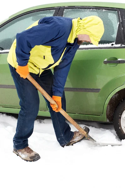 Человек копает автомобильные колеса из снега — стоковое фото
