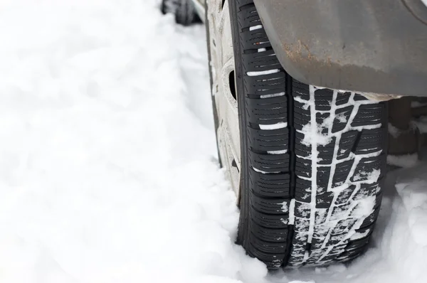 車のホイールは雪の中で立ち往生しています — ストック写真