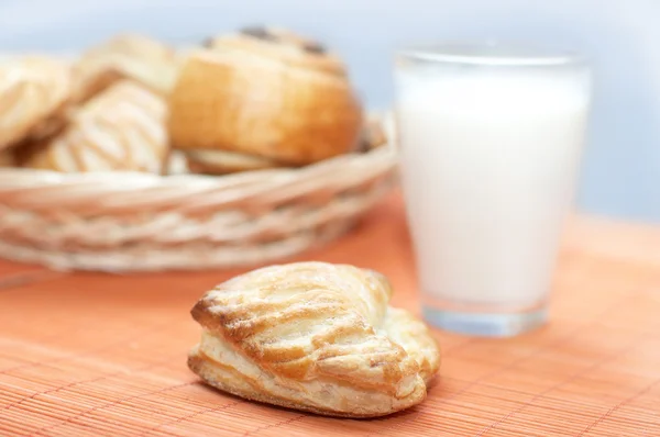 stock image Puff pastry and glass with milk on bamboo place mat