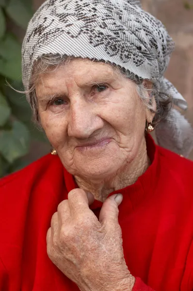 stock image Smiling old woman in red sweater and headscarf