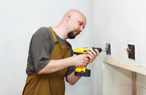 Worker with screwdriver driving screw — Stock Photo, Image