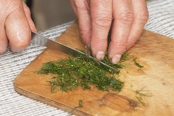 Stock image Cooking: woman hands cutting dill by kitchen knife