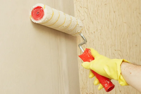 Mão em glothes parede lubrificante na cola para papel de parede — Fotografia de Stock