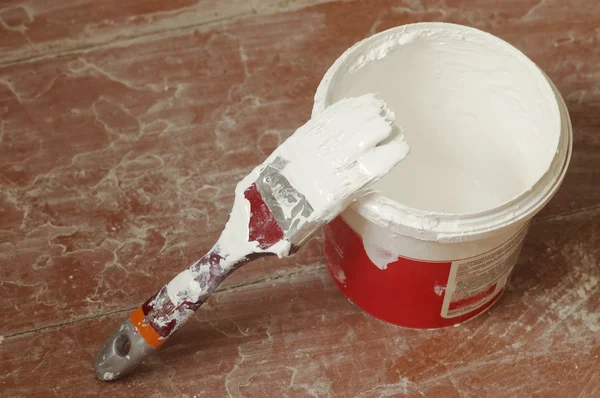 Processus de rénovation : Brosse imbibée de peinture blanche et pot — Photo