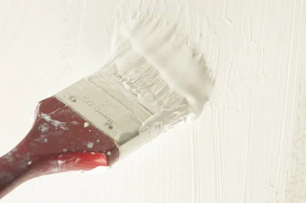 Proceso de renovación: Cepillo empapado en pintura blanca para colorear la pared —  Fotos de Stock