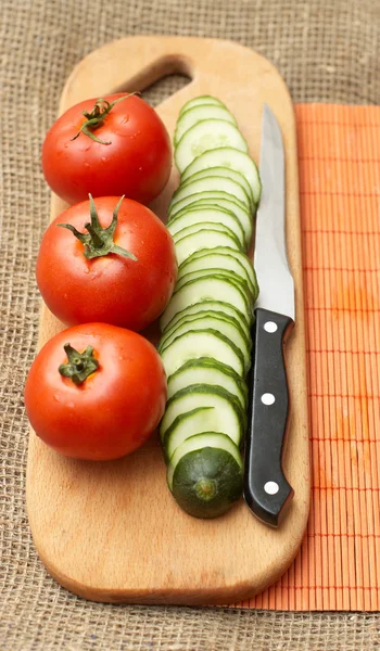 stock image Tomatoes, cucumber and knife on kitchen board