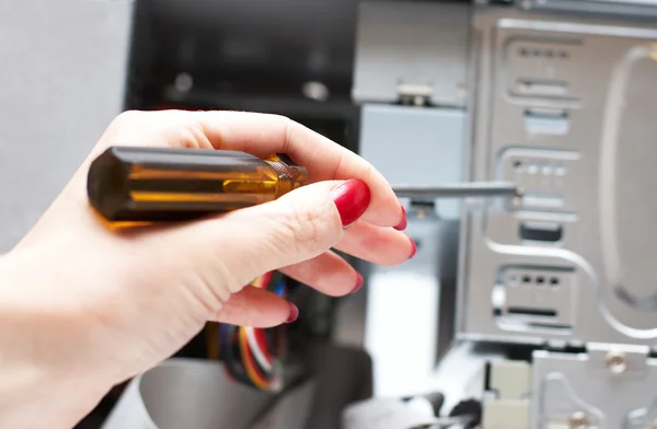 Женская рука с отверткой. Компьютер на ремонте . — стоковое фото