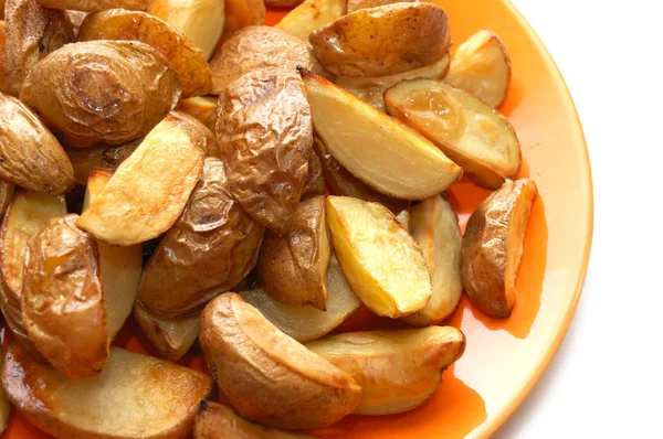 Batatas assadas em suas jaquetas em prato laranja — Fotografia de Stock