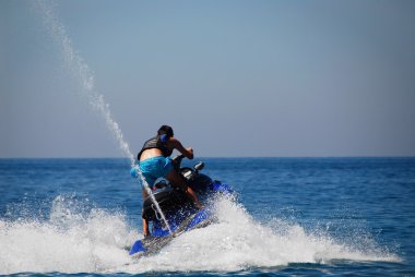 Man in action with his jet-ski clipart