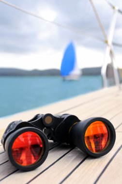 Close up on binocular on deck of yacht with another yacht on horizon in natural blur. Picture taken on match race in Boka bay, Tivat, Montenegro clipart