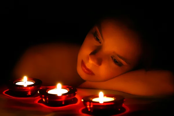 Жінка дивиться на три свічки — стокове фото