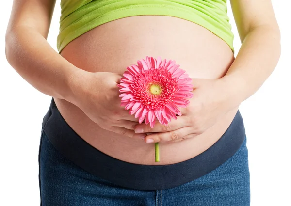 Mujer embarazada con una flor — Foto de Stock