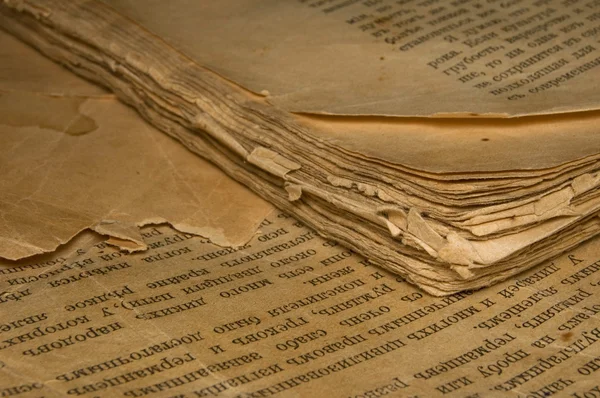 Крупный план старой книги с изодранными страницами и славянским текстом — стоковое фото